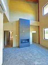 Primary bedroom with towering ceiling, office sized walk-in closet and custom tiled fireplace.