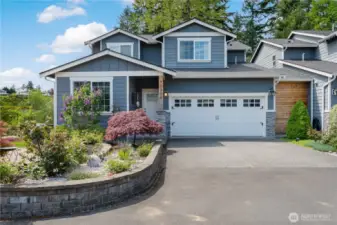 The inviting front of the house with the raised bed and rose garden.