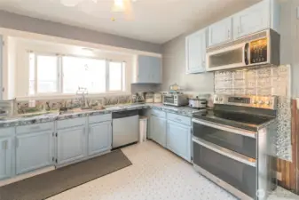 Bright, updated kitchen with new sink and generous cabinetry providing ample storage.