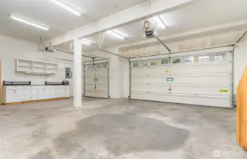 Three-car garage with EV Charger, Generator, RV plug & shop space.