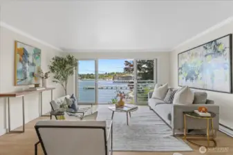 A spacious living room with a picturesque window framing ever changing Lake WA views!
