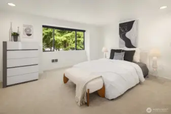 Spacious Primary Suite on the second level with two closets overlooks front Patio and green space.