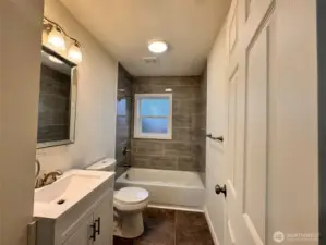 Brand new bathroom with tile shower and floor.