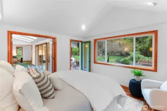 Primary bedroom access to main living area and its own door to back deck and garden.