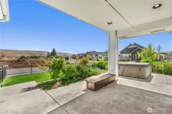 Covered patio for outdoor living with built-in propane fireplace.