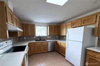 Light filled kitchen open to hallway and dining room