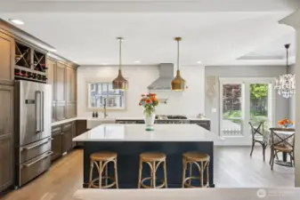 Impeccably designed for both everyday luxury and entertaining, this gourmet kitchen boasts a grand quartz island with seating, custom cabinetry, and brushed gold pendant lighting. A professional-grade Thor range with double ovens and pot filler, along with a farmhouse sink and built-in wine storage, create a chef-worthy workspace infused with refined style