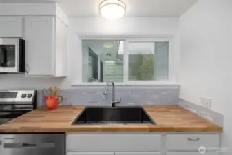 Kitchen with new sink and window that looks out over the patio.