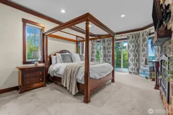 Primary bedroom with deck access and fireplace