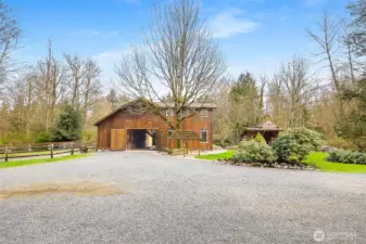 Barn/stalls w/large loft area on the left and house on the right.    Entertainment building to the far right.