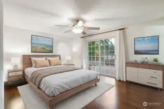 Virtually staged primary bedroom. Notice ceiling fan to keep you cool, slider that opens to expansive back deck. There's an ensuite located to the right. Closet on the left.