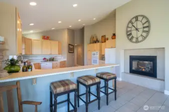 Bright and open kitchen with eating area and see through fireplace.