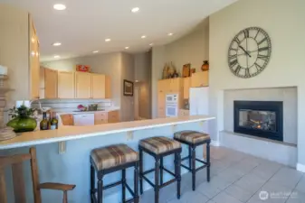 Bright and open kitchen with eating area and see through fireplace.