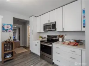 White counter tops and stainless steel appliances that all convey with the home.