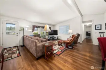 Light-filled living room features durable laminate wood flooring and a spacious layout designed for comfortable, easy living.