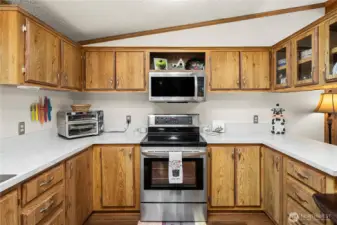 Kitchen features a stainless steel electric range with microwave, complemented by generous cabinetry and an efficient layout for everyday cooking.