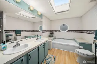 Primary bathroom includes dual-sink vanity, NEW skylight, soaking tub, walk-in shower and ample space for a bright, functional daily routine.