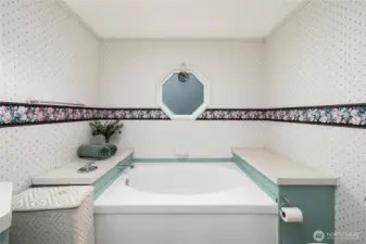 Soaking tub offers a relaxing space to unwind, enhanced by natural light and a serene spa-like feel.