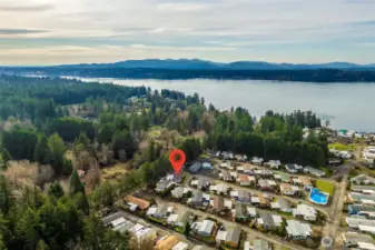 Aerial view highlights the home’s proximity to the Puget Sound, set within a peaceful, well-established 55+ community.