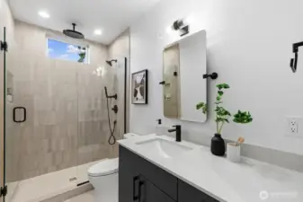 Luxurious primary bathroom with rainfall shower head.