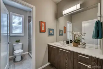 Guest bathroom with quarts counters and tile floors is conveinantly located between the additional bedrooms.