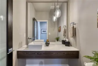 Stylish powder room with sleek vessel sink.