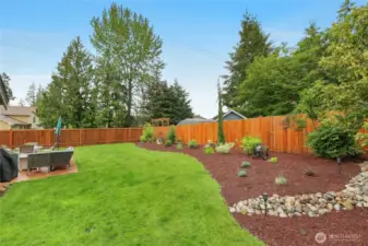 Beautiful, sunny, and fully fenced backyard with wonderful landscaping.