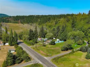 The property surrounds the current home and extends down Hwy 101 to the top left of the photo with a cedar forest to the top right.