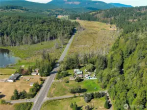 The 12+ acres surround the home mid photos. The wetlands are home to many birds and other wildlife. Beaver heaven.