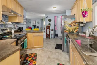 View of the kitchen looking back at entrance and remodeled laundry area that features Washer/Dryer combo stainless steel brand NEW and energy efficent with built-ins for storage.