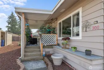 Front Porch entrance with more areas to add plants or storage! Easy to care for red rock as part of your landscaping!