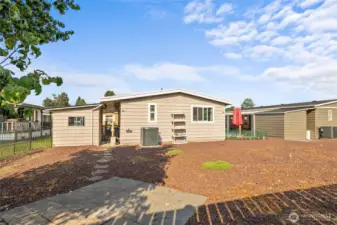 Another view of back yard, pavers in place for your firepit or extra hang out area, looking back at home and New Heat Pump, storage shed and path to back patio carport.