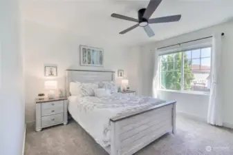 Large primary bedroom with custom room darkening shades, ceiling fan w/ light