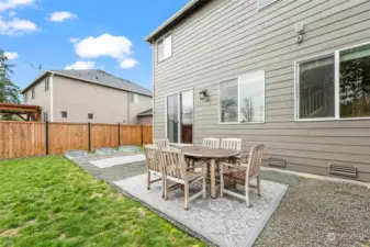 From the back steps to the end of the house near the raised garden beds has a cement slab that is currently covered with gravel