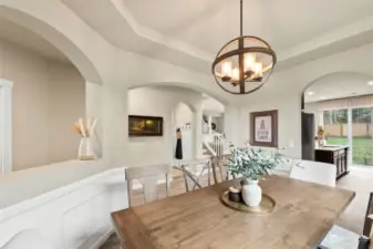 The door to the left (hardly pictured) is the office/den. The dining room features coffered ceiling, custom lighting, and a beautiful room for gathering