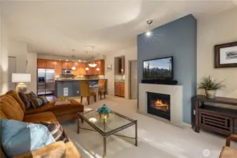 The inviting living room is designed for comfort and entertainment, featuring a mounted TV, sound system, and a cozy gas fireplace that creates the perfect ambiance. Whether you're unwinding or entertaining guests, this space offers both warmth and modern conveniences.