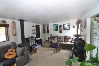 Back house living room, showing a bit of kitchen to the right, and hallway to the bedroom.