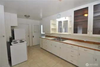 Front house kitchen is quite large with tons of storage space and room for a table and chairs.