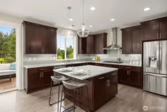 Chef's kitchen with gas range, under cabinet lighting and designer light fixtures