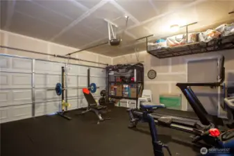 two car garage with overhead storage, tankless water heater, and exterior side door