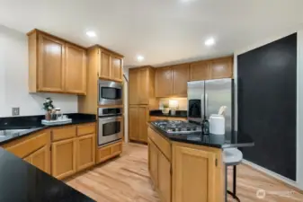 Granite countertops and solid wood cabinets and cool blackboard wall to write grocery lists, meal plans and notes to your family