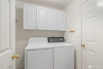 Dedicated laundry room between the entry and garage. Additional storage space behind the door to the left.