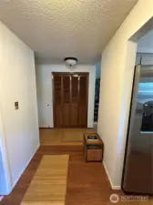 Entry hallway, laundry room to the left and kitchen to the right