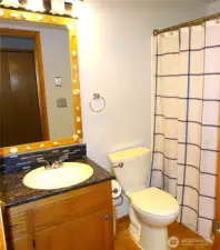 Main Bathroom With Oak Hardwood Floor and Granite Countertop.