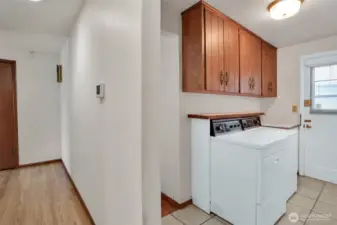 Laundry room sits right behind the kitchen, door leads to the side yard, off to the right is a 3/4 bath.