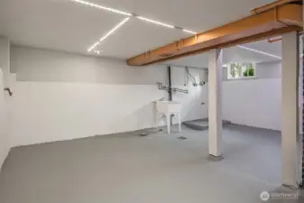 The basement features an interior staircase and is fully sheetrocked. The washer and dryer go next to the laundry sink. A brand new hi-efficiency furnace and water heater are unseen to the right.