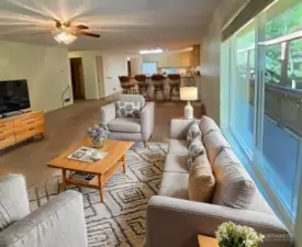 living room virtually staged, shows how it flows into kitchen and dining area