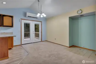 White double doors in upstairs living room lead outside to raised deck space