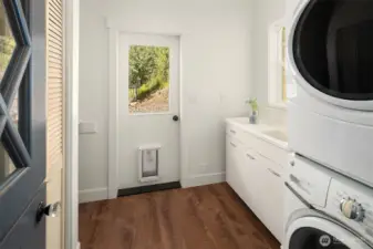 Laundry room has plenty of storage, laundry sink and stackable washer/dryer. Door leads out to back yard, perfect for your four legged friends to romp and play