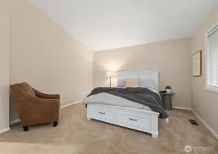 Large primary bedroom upstairs with vaulted ceilings.
